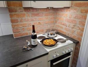 a bottle of wine and a bowl of food on a stove at Litet mysigt hus i Östra Göinge in Västraby