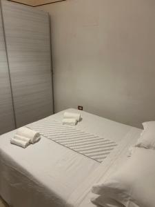 a white bed with two towels on top of it at ViaReposati30 in Gubbio