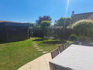 a backyard with a table and a fence at maison 3 chambres 24h le mans in Le Mans +1 photo