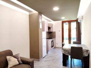 a living room with a table and a kitchen at SUITE GUEST HOUSE a pochi minuti dal Mare in Sassari