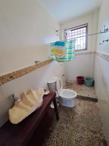 a bathroom with a toilet and a sink at Sandybridge Eco Farm at Relly's Restaurant in Puerto Princesa City