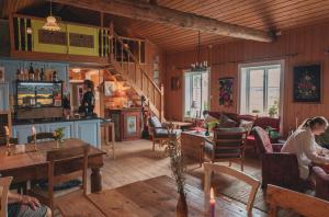 a living room with people sitting in chairs and tables at PAN Treetop Cabins in Åsnes