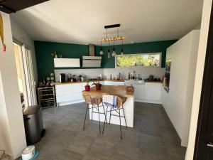 eine Küche mit grünen Wänden und einem Tisch und Stühlen in der Unterkunft 2 Chambres 25m2 à 9min circuit du Mans in Voivres-lès-le-Mans + 3 Fotos