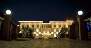 a large white building at night with lights at Silver Palm Hotel & Resorts in Malaut