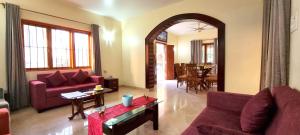 a living room with a red couch and a table at Thor Villa, 5BHK-Private Pool-Cook-Caretaker in Assagao +37 photos