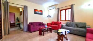 a living room with two couches and a table at Thor Villa, 5BHK-Private Pool-Cook-Caretaker in Assagao