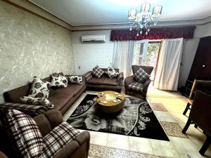 a living room with a couch and a table at شقة غرفتين نوم بحديقة خاصة في المعمورة الشاطئ دور أرضي in Alexandria