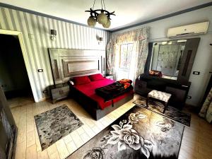 a living room with a red couch and a mirror at شقة غرفتين نوم بحديقة خاصة في المعمورة الشاطئ دور أرضي in Alexandria