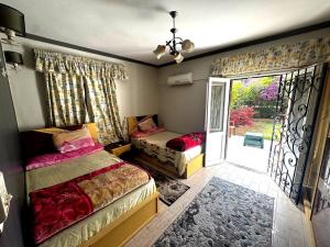 a bedroom with two beds and a sliding glass door at شقة غرفتين نوم بحديقة خاصة في المعمورة الشاطئ دور أرضي in Alexandria