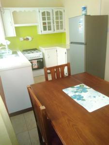 a kitchen with a wooden table and a refrigerator at Orange Building 2 in Saint Georges in Saint Georgeʼs +5 photos