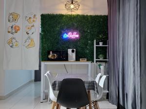 a dining room with a table and a green wall at Deen Paddy View Wifi 3 Airconds in Alor Setar