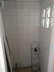 a tiled shower with a shelf and a window at Humlesten's Gård in Huaröd