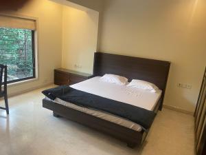 een slaapkamer met een groot bed met een groot raam bij Penthouse retreat by speed homes in Calcutta