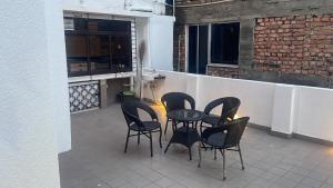 een patio met 4 stoelen en een tafel op een balkon bij Penthouse retreat by speed homes in Calcutta