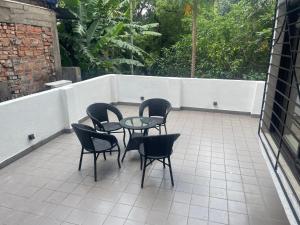 een patio met 4 stoelen en een glazen tafel bij Penthouse retreat by speed homes in Calcutta