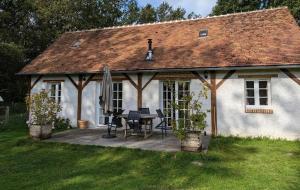 a white house with a table and chairs in front of it at La Sauvagine in Villemurlin