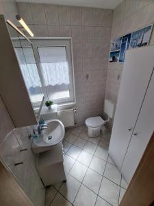 a bathroom with a sink and a toilet and a window at Ferienhaus Leonie in Barth