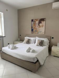 una camera da letto con un letto grande con lenzuola bianche di Enjoy Home Sorrento a Sorrento