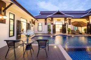 a villa with a swimming pool and a house at Modern Lanna Style Grand Pool Villa in Chiang Mai