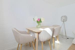 une table de salle à manger avec des chaises et un vase de fleurs dans l'établissement Souterrain in Timmendorfer Strand - Niendorf Ostsee, à Timmendorfer Strand