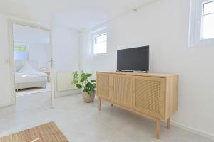 - un salon avec une télévision au-dessus d'une armoire dans l'établissement Souterrain in Timmendorfer Strand - Niendorf Ostsee, à Timmendorfer Strand