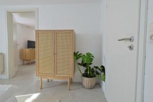 une armoire en osier dans une pièce avec une plante en pot dans l'établissement Souterrain in Timmendorfer Strand - Niendorf Ostsee, à Timmendorfer Strand 4 autres photos