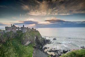 a castle on a cliff next to the ocean at Roxy's Place in Portballintrae