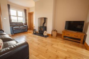 a living room with a couch and a fire place at Roxy's Place in Portballintrae