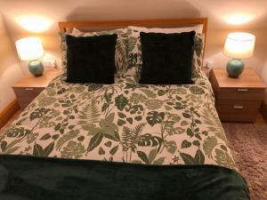 a bedroom with a bed with two lamps on two tables at Roxy's Place in Portballintrae