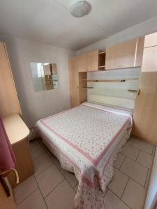 a small bedroom with a bed in a room at Camping Al Lago Ledro in Ledro