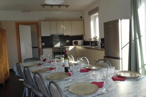 a long table with chairs and plates and wine glasses at Au coin de détente in Durbuy