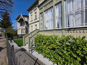 Biały dom z płotem i krzakami w obiekcie Sopot Special Apartments w mieście Sopot
