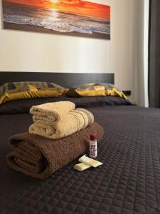 a bed with a pile of towels and a bottle of medicine at LORY ROOM vacation home in Quartu SantʼElena +9 photos