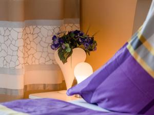 a vase with a flower on a table with a pillow at Ferienwohnung Harlachbergblick 1-Activ Card in Bodenmais