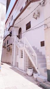 a white building with stairs on the side of it at Karibu Nyumbani in Zanzibar City