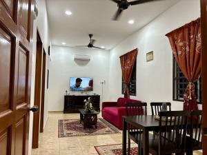 a living room with a red couch and a table at Pelangi Highway Homestay Biru,A5 in Sungai Mati