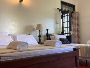a bedroom with two beds with towels on them at Woodlands Homestay - Kandy in Teldeniya