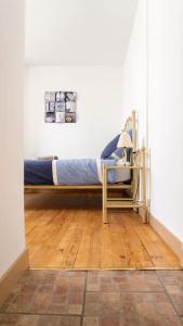 a bedroom with a bed and a chair on a wooden floor at Appart' des Tours de La Rochelle in Aytré