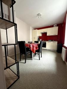 a room with a table and chairs and a kitchen at T3 Hyper centre Place des Vosges in Épinal +4 photos