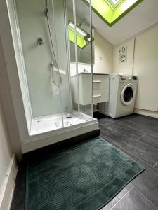 a bathroom with a shower and a washing machine at T3 Hyper centre Place des Vosges in Épinal