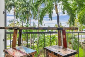 NightcliffBeachfront Bliss Studio Apt On The Foreshore的棕榈树阳台的木凳