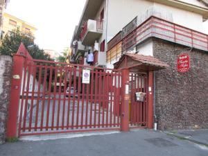 a red gate in front of a building with a stop sign at B&B Santa Sofia in Gravina di Catania
