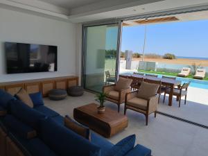 a living room with a blue couch and a table at Blue Aura Beach villa Larnaca in Pervolia