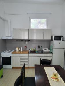 a kitchen with white cabinets and a table and a sink at BIG APARTMAN BELA CRKVA in Bela Crkva +6 photos