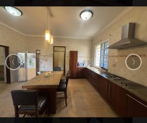 a large kitchen with a table and a refrigerator at Villa Zara in Zanzibar City