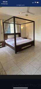 a bed with a glass frame in a room at Villa Zara in Zanzibar City