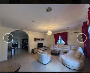 a living room with white couches and a tv at Villa Zara in Zanzibar City