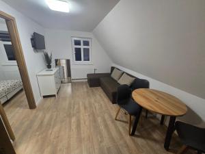una sala de estar con un sofá y una mesa en Agroturystyka Stajnia Horyzont, en Jarosławiec