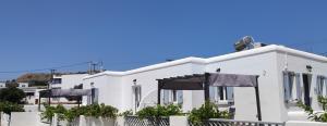 a white building with black umbrellas in front of it at Chrysiis House 1 in Maltezana +12 photos