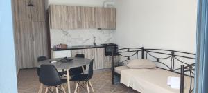 a bedroom with a bed and a table and chairs at Chrysiis House 1 in Maltezana